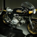 Vintage Ducati 900 Super Sport bike on showroom floor, highlighting classic design.