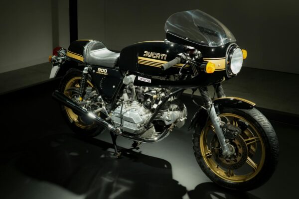 Vintage Ducati 900 Super Sport bike on showroom floor, highlighting classic design.