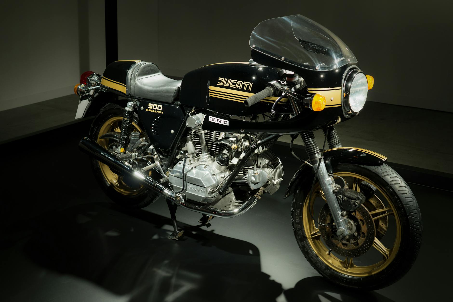 Vintage Ducati 900 Super Sport bike on showroom floor, highlighting classic design.