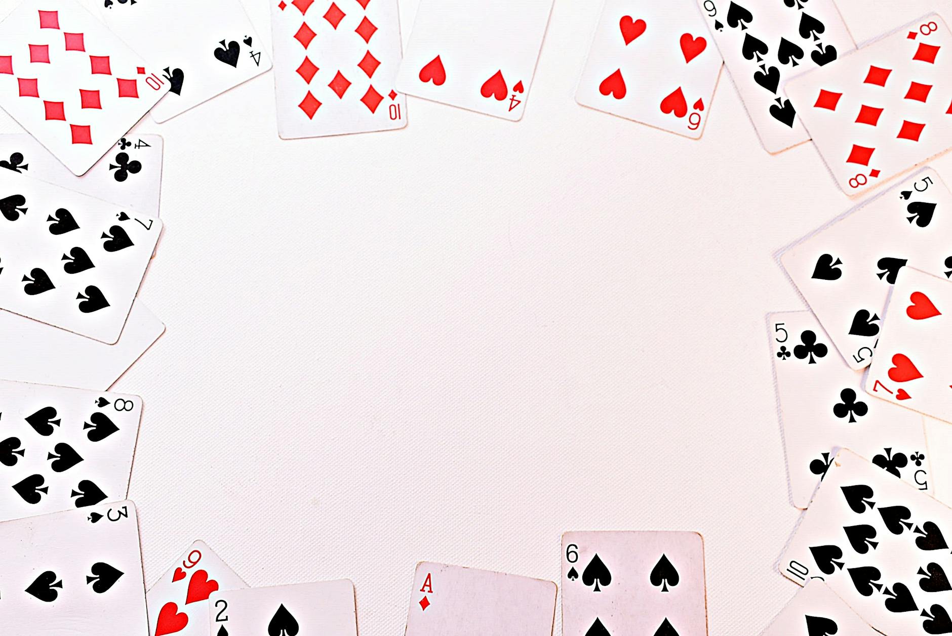 A circle of dispersed playing cards on a white surface, perfect for games and gambling themes.