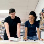 Two engineers collaborate in a workshop, engaging in hands-on prototyping and design.