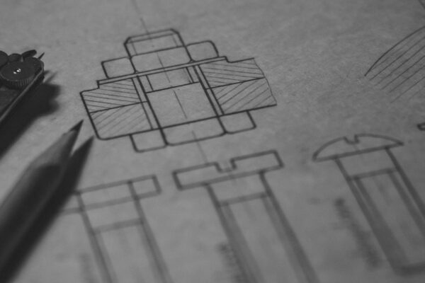 Detailed technical blueprint with pencil and compass illustrating engineering design concepts.
