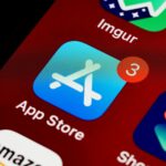 Close-up of App Store icon on iPhone screen with notification badge, highlighting app updates.